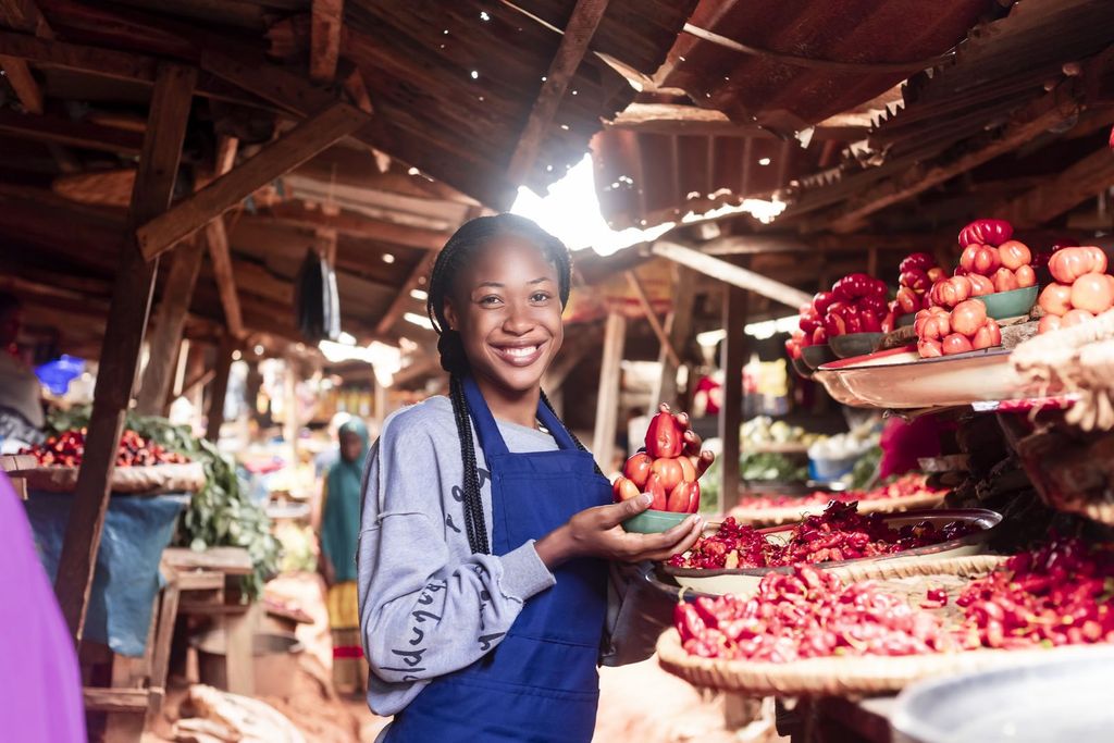 A vendor selling tomatoes and vegetables at a local market